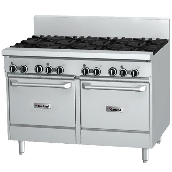 A white Garland commercial gas range with black knobs and two ovens.