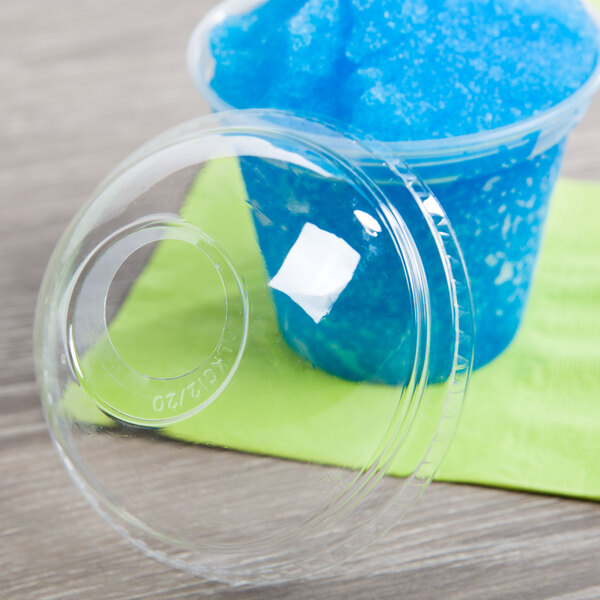 A Fabri-Kal clear plastic dome lid on a plastic container with blue substance in it.
