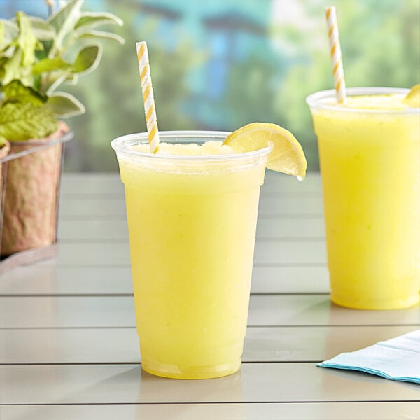 Two cups of lemonade with yellow straws in Fabri-Kal clear plastic cups.