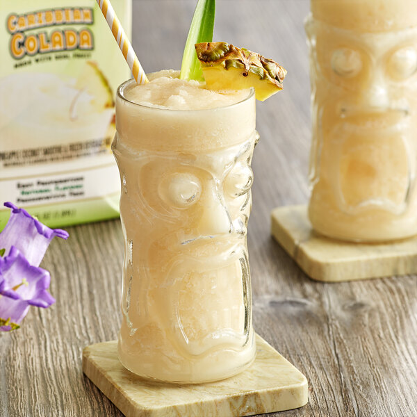 A glass of DaVinci Gourmet Caribbean Colada Real Fruit Smoothie Mix with a pineapple on the rim.