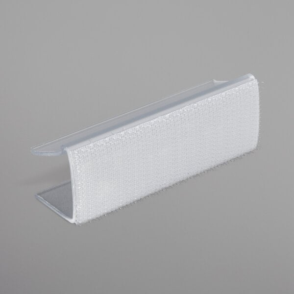 A clear plastic Snap Drape table skirt clip with a clear plastic strip and hook.