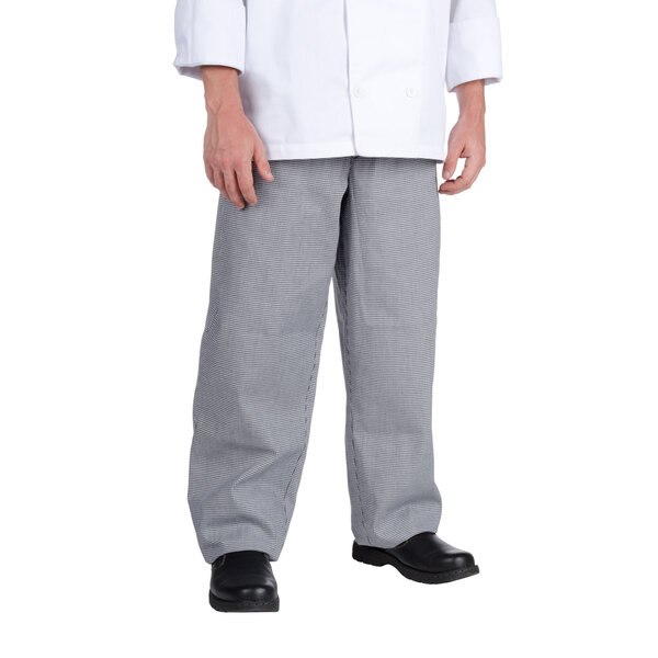 A person wearing Chef Revival houndstooth chef pants and a white coat.