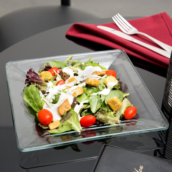 A salad on a Libbey glass square plate.