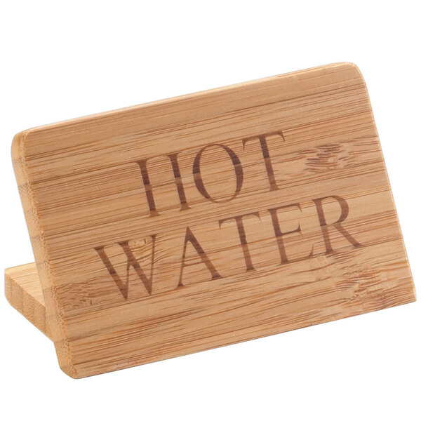 A Cal-Mil bamboo wood sign that says "Hot Water" on a counter.