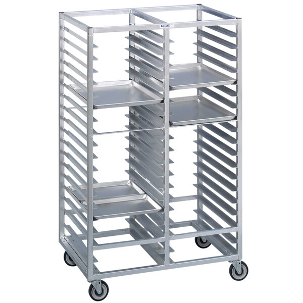 A Channel metal tray rack with shelves holding four aluminum trays on wheels.