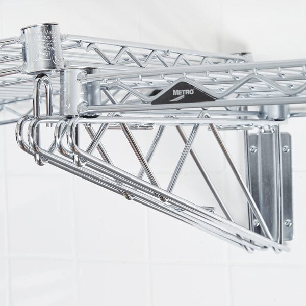 A Metro chrome wall mount bracket attached to a metal wall.
