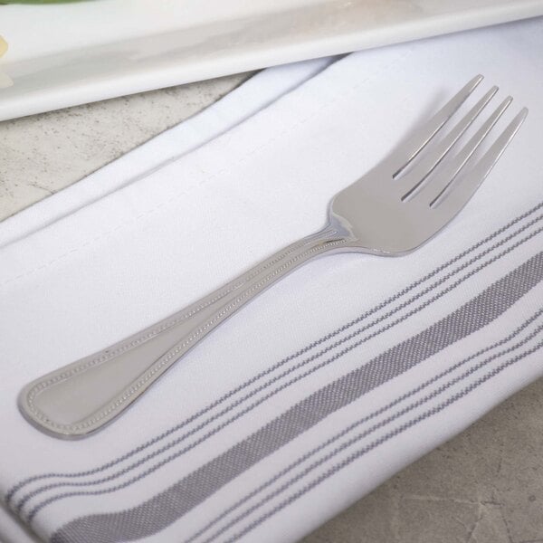 A 10 Strawberry Street Pearl stainless steel salad fork on a napkin.