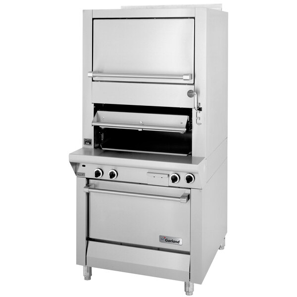 A large stainless steel Garland upright broiler with finishing oven and storage drawers.