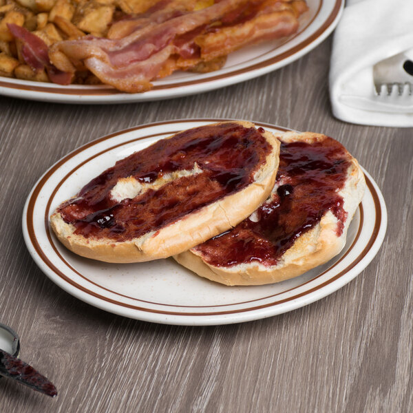 A Tuxton brown speckle narrow rim china plate with food including two pieces of toast with jam and bacon.