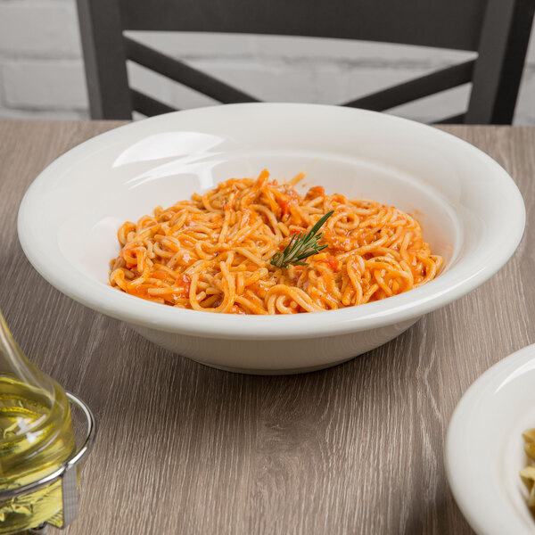 A Tuxton eggshell china pasta bowl filled with spaghetti on a table.
