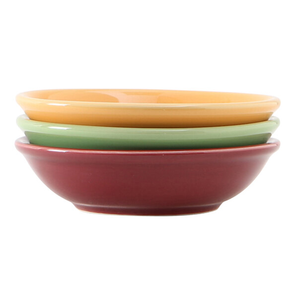 A stack of Tuxton sauce dishes in assorted colors.