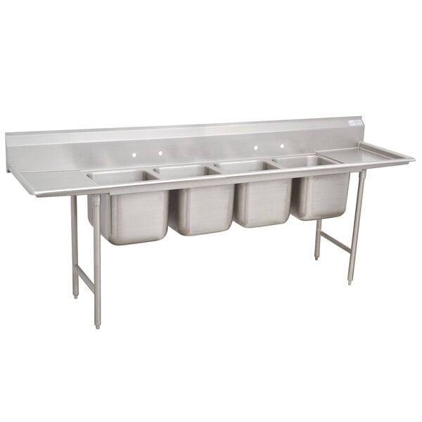 A stainless steel Advance Tabco Regaline four compartment sink with two drainboards.