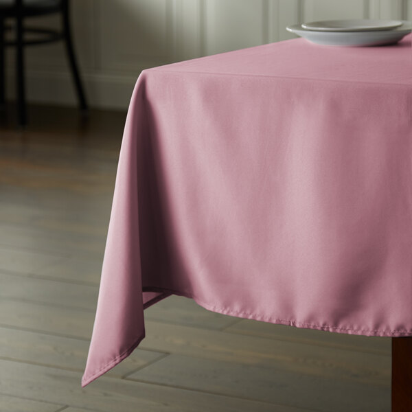 A table with a pink Intedge square tablecloth.