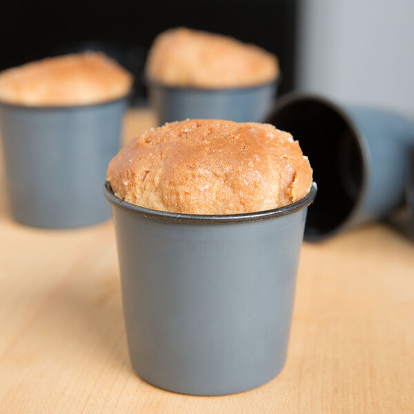 A group of Matfer Bourgeat rum baba molds with food in them.