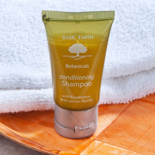 A bottle of Basic Earth Botanicals conditioning shampoo on a towel.