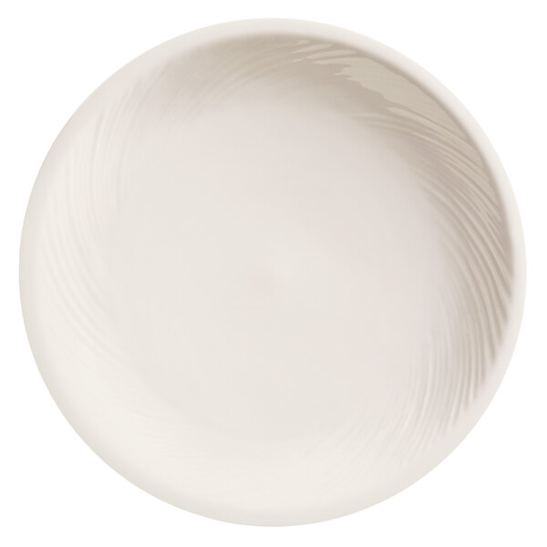 A close-up of a Libbey bright white porcelain plate with wavy lines on it.