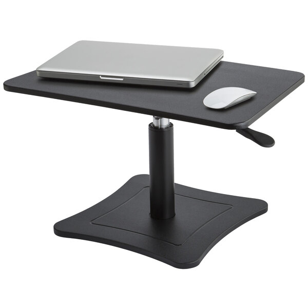 A Victor black wood adjustable height laptop stand on a table with a laptop and mouse.