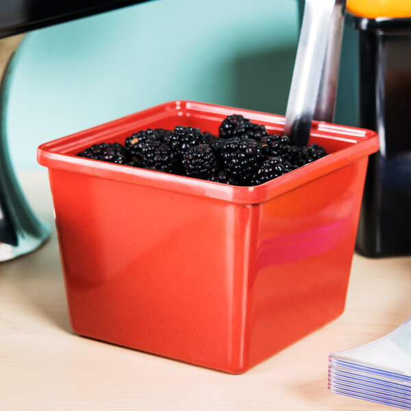 A red square GET Melamine crock with blackberries in it.