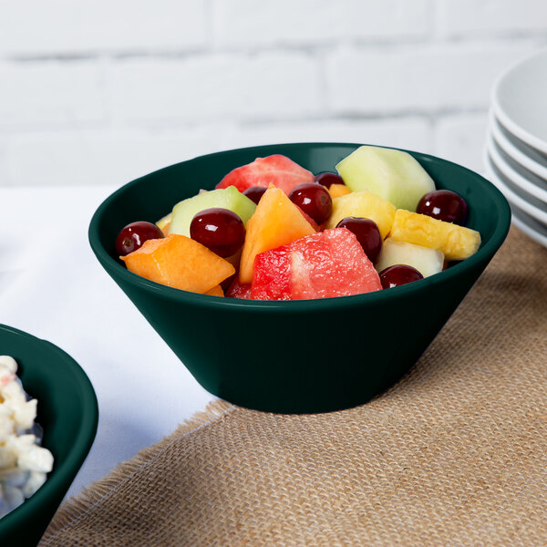 A Tablecraft hunter green and white speckled cast aluminum bowl filled with fruit salad on a table.
