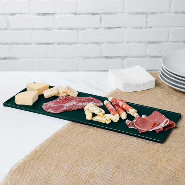 A hunter green cast aluminum rectangular cooling platter with meat and cheese on it.