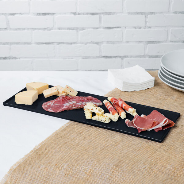 A Tablecraft midnight black cast aluminum rectangular cooling platter with blue speckles holding a variety of meats and cheeses.