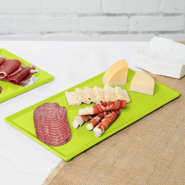 A Tablecraft lime green rectangular cast aluminum cooling platter with food on it.