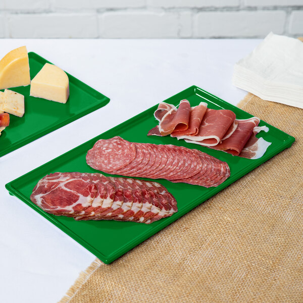 Two Tablecraft green cast aluminum rectangular trays of meat and cheese.