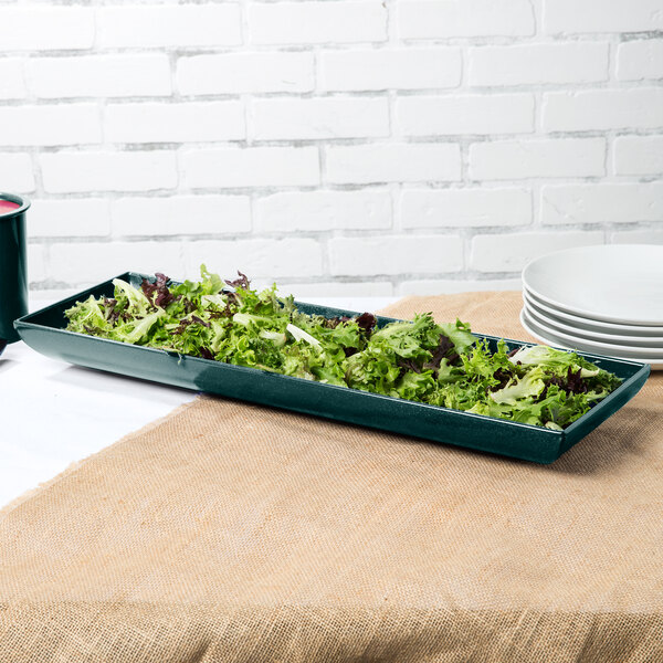 A hunter green cast aluminum rectangular platter with lettuce on it.
