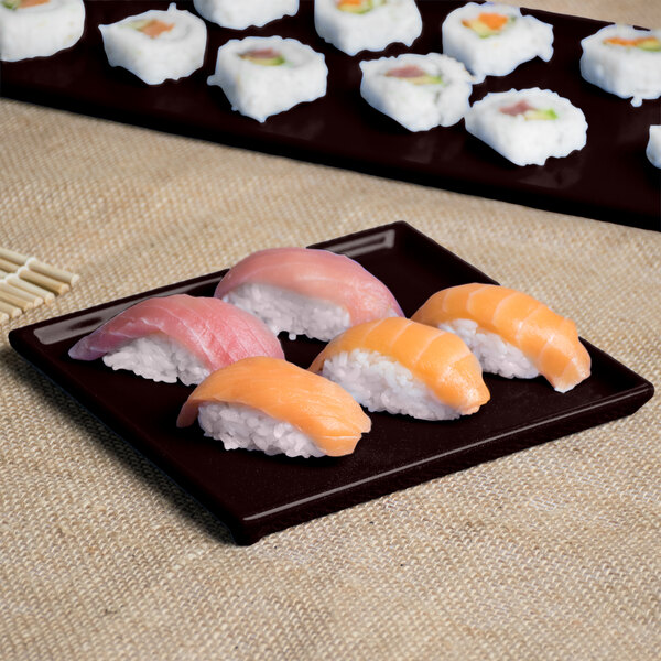 A Tablecraft midnight speckle rectangular cast aluminum cooling platter with sushi on a table.
