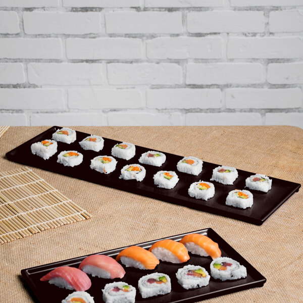 A Tablecraft Midnight Speckle cast aluminum half long rectangular cooling platter on a table with sushi.