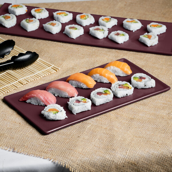 A Maroon speckle cast aluminum rectangular Tablecraft cooling platter with sushi on it.
