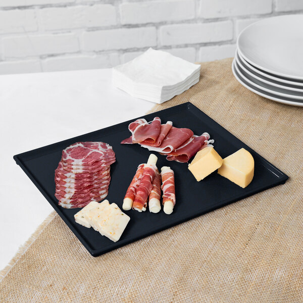 A Tablecraft Midnight with Blue Speckle cast aluminum rectangular cooling platter with meat and cheese on a table.