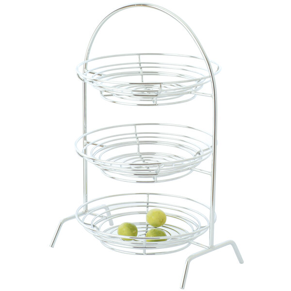 A 2-tier chrome plated iron riser with Clipper Mill by GET in a metal basket with fruit.