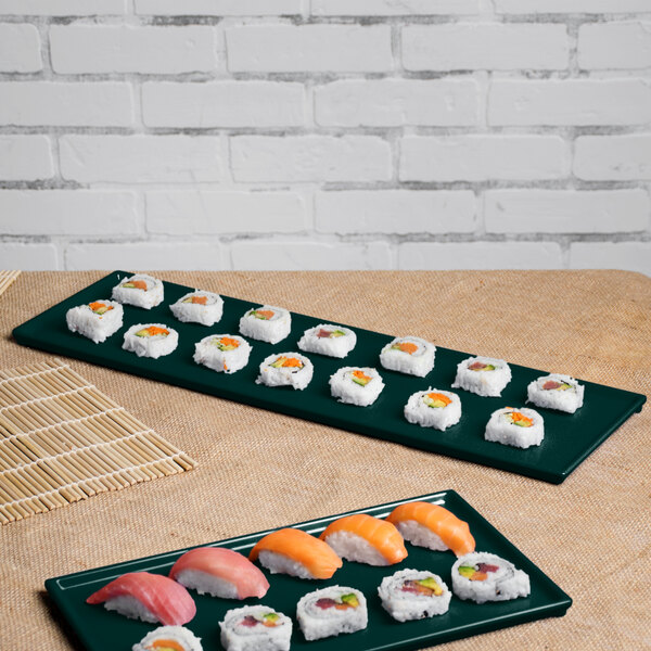 Two hunter green and white speckled Tablecraft rectangular cooling platters with sushi on a table.