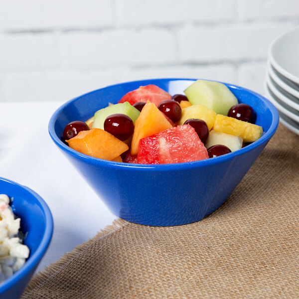 A blue Tablecraft cast aluminum bowl with fruit salad in it.