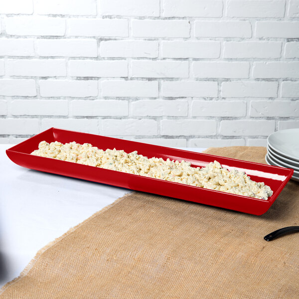 A red rectangular Tablecraft tray with food in it.