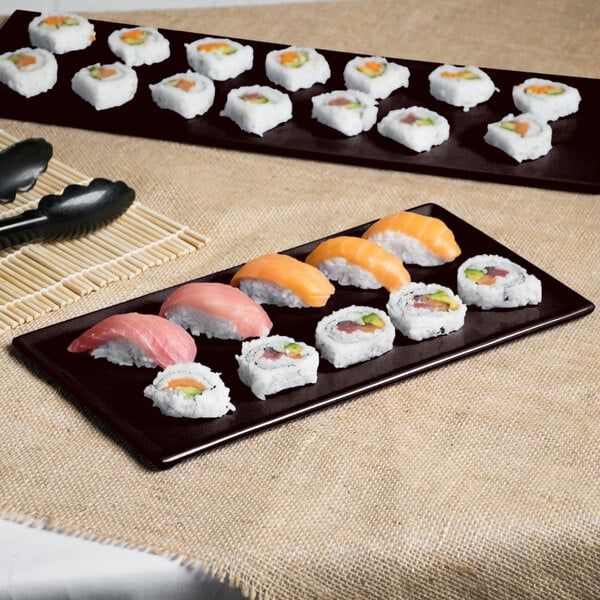 A Tablecraft midnight speckle rectangular metal cooling platter with sushi on it.