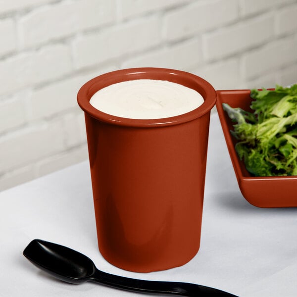 A red Tablecraft salad dressing crock filled with white liquid.