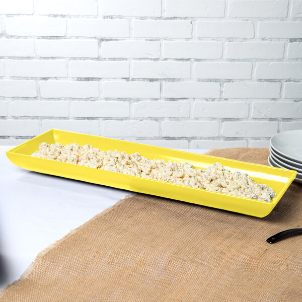 A yellow rectangular tray with food on it.