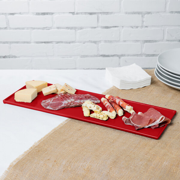A red Tablecraft rectangular cooling platter with different types of meats and cheese on it.