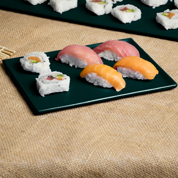 A Tablecraft Hunter Green and White Speckle rectangular cast aluminum cooling platter with sushi on a table.