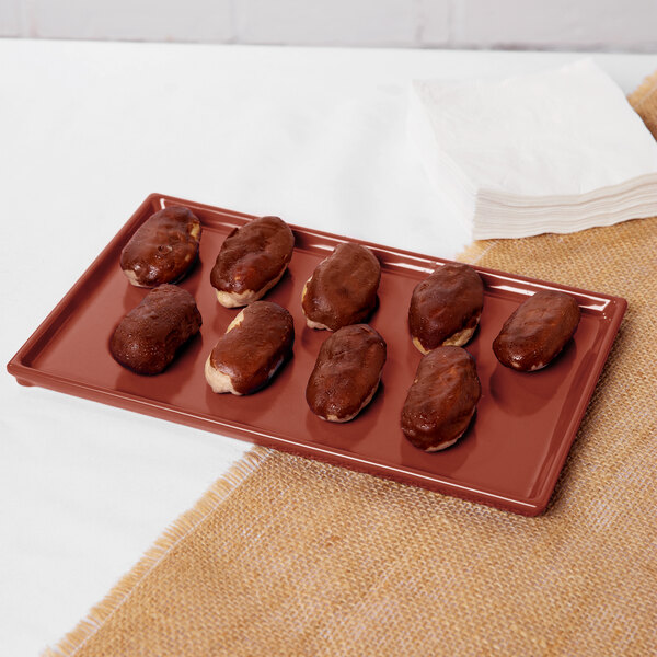 A Tablecraft copper cast aluminum rectangular cooling platter holding chocolate covered desserts.