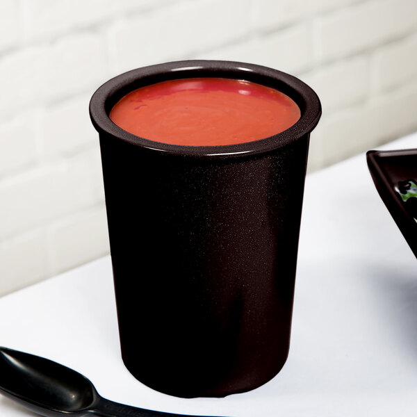 A Tablecraft black and white speckled cast aluminum salad dressing crock with a red lid.