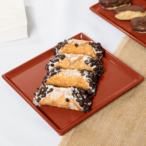 A copper rectangular Tablecraft cooling platter with chocolate covered pastries on it.