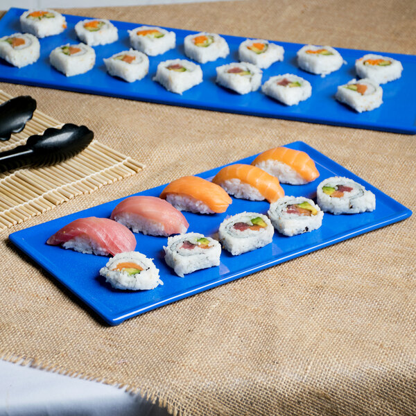 A blue speckled rectangular cast aluminum cooling platter with sushi on it.