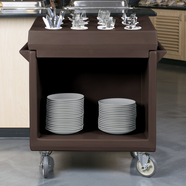 A dark brown Cambro dish cart with plates and utensils on it.