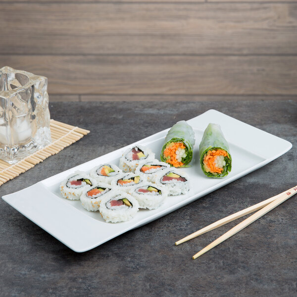 A rectangular white Schonwald porcelain platter with sushi and chopsticks on it.
