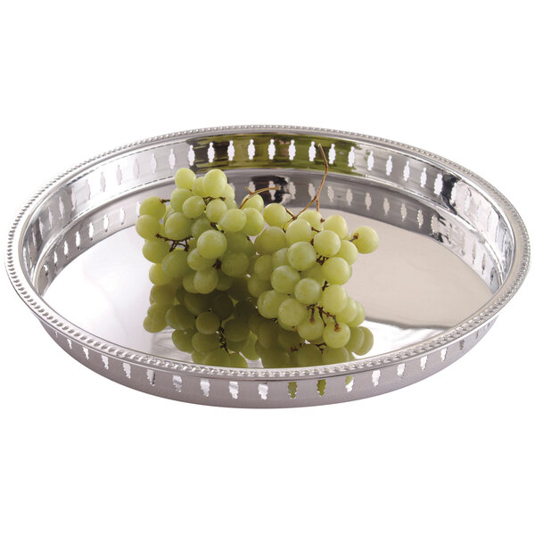 A Clipper Mill stainless steel round tray with a bunch of grapes on it.