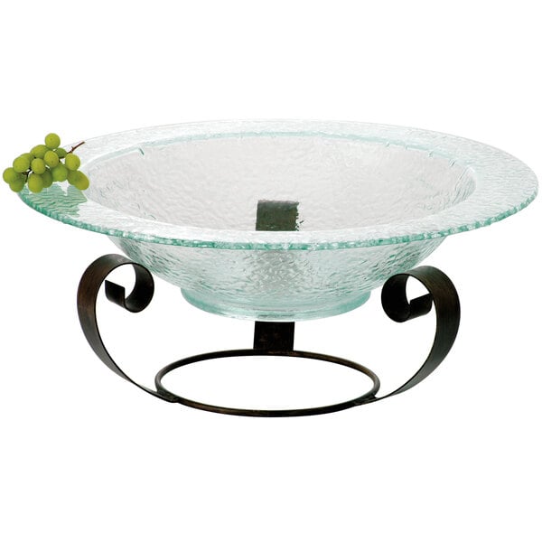 A brown turtle shell iron curl riser with a glass bowl of grapes on top.