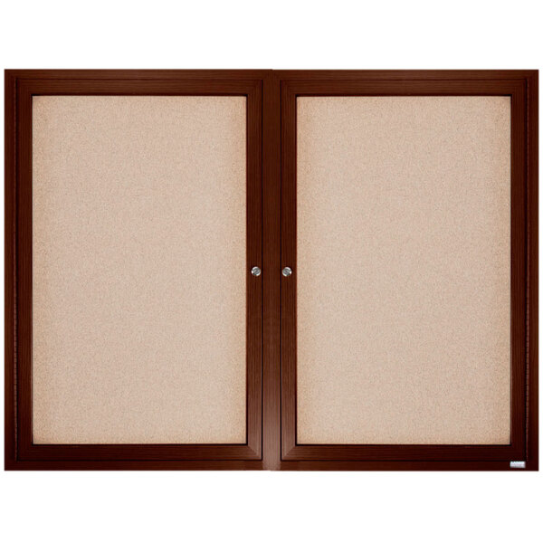 A brown wooden framed Aarco enclosed bulletin board.